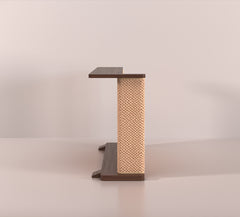 A Cat-e-Corner table placed next to a sofa, integrating a cat's scratching post with a small table, in a room with a plant and a colorful cushion.