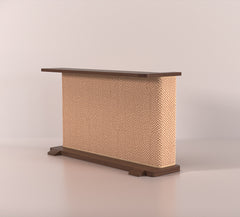 A Cat-e-Corner table placed next to a sofa, integrating a cat's scratching post with a small table, in a room with a plant and a colorful cushion.