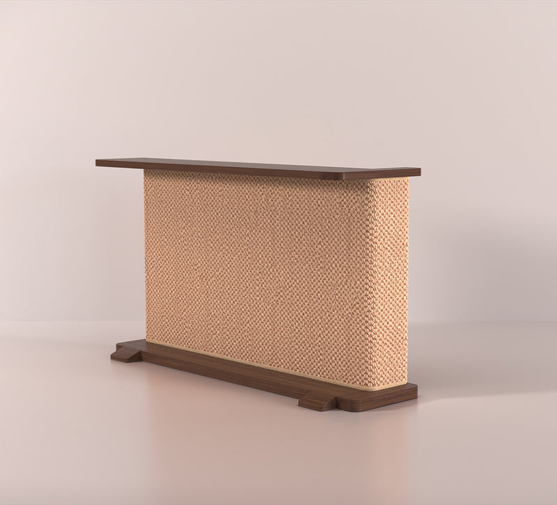 A Cat-e-Corner table placed next to a sofa, integrating a cat's scratching post with a small table, in a room with a plant and a colorful cushion.