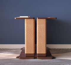 A Cat-e-Corner table placed next to a sofa, integrating a cat's scratching post with a small table, in a room with a plant and a colorful cushion.