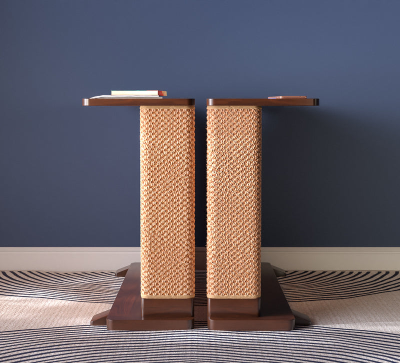 A Cat-e-Corner table placed next to a sofa, integrating a cat's scratching post with a small table, in a room with a plant and a colorful cushion.