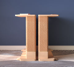 A Cat-e-Corner table placed next to a sofa, integrating a cat's scratching post with a small table, in a room with a plant and a colorful cushion.